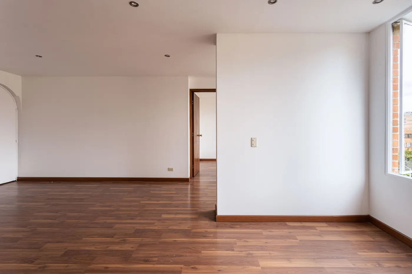 Stock photo of an empty room with wood floors and white walls